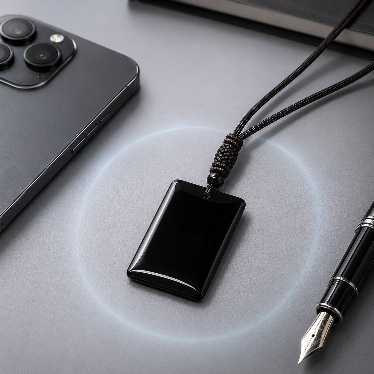 Black obsidian pendant resting on a desk