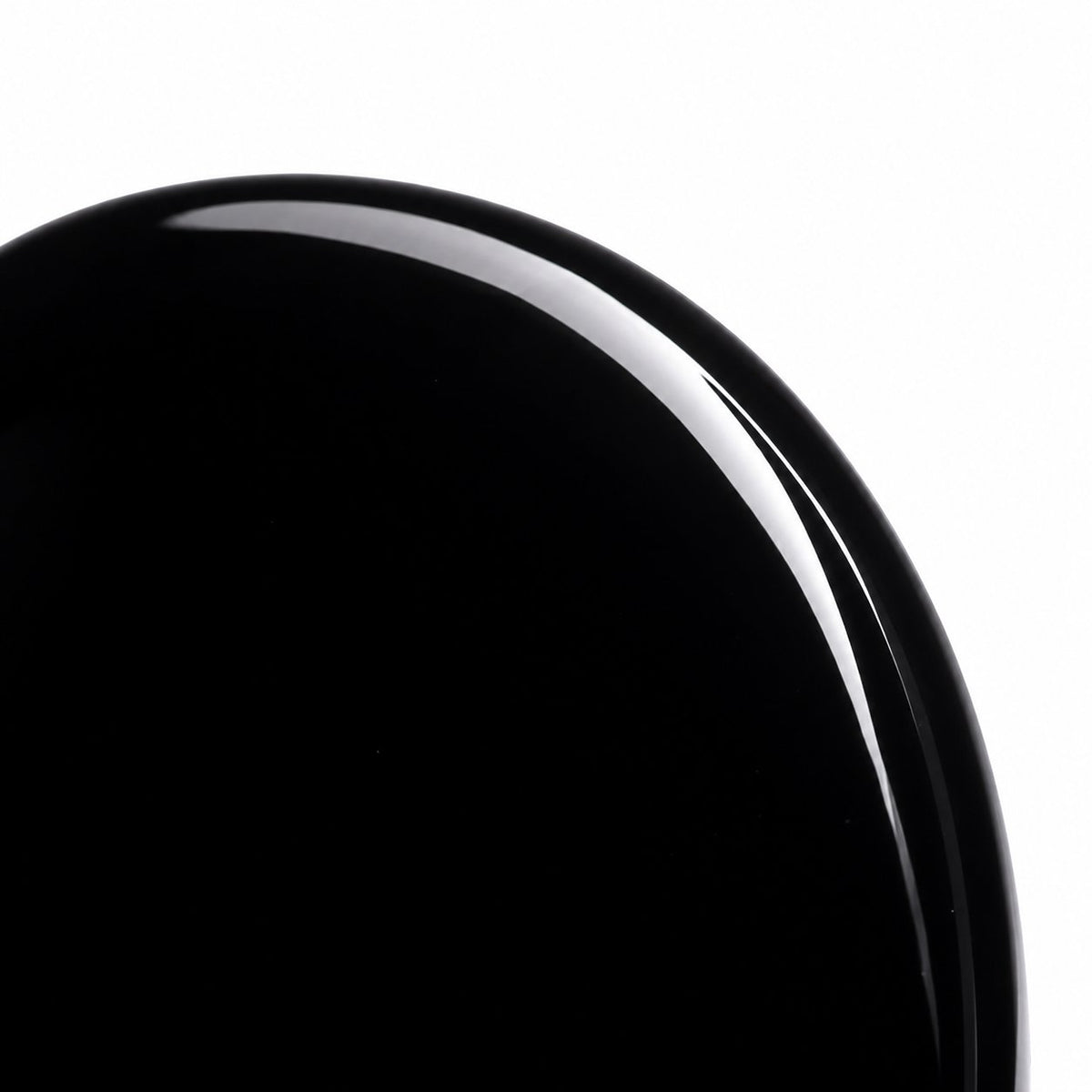 Close-up of polished black obsidian palm stone surface