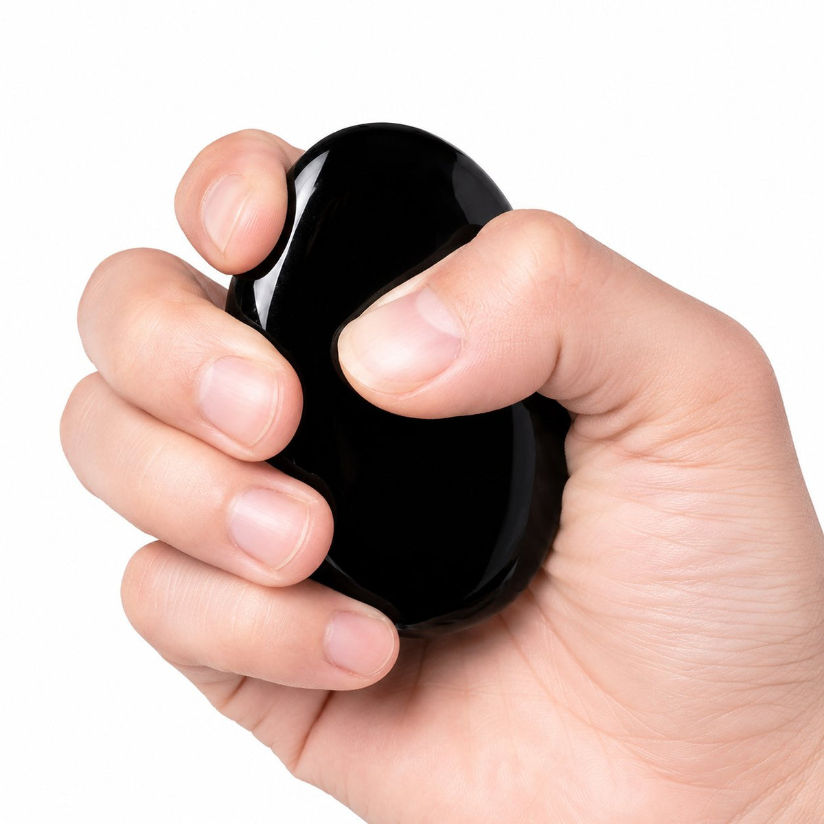 Hand holding a black obsidian palm stone