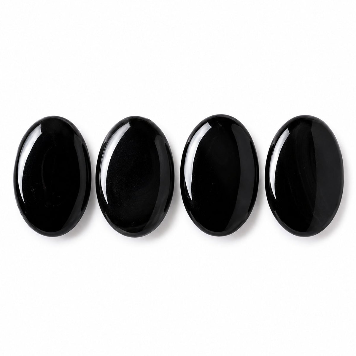 Group of black obsidian palm stones showing natural shape variation